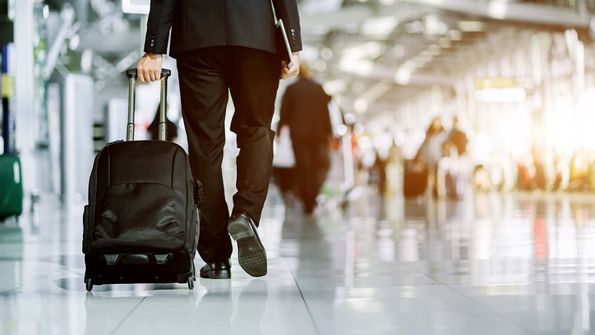 Man mit Koffer am Flughafen